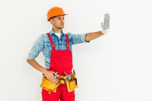 Spettacoli fermare cartello di mano. costruzione lavoratore nel uniforme e sicurezza attrezzatura avere lavoro su edificio foto