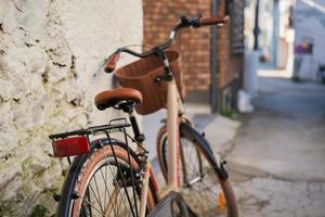 moderno bicicletta nel retrò stile su il strada nel il vecchio cittadina, selettivo messa a fuoco. accogliente vecchio strada idea per arredamento e interno design. foto