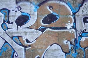 frammento di graffiti disegni. il vecchio parete decorato con dipingere macchie nel il stile di strada arte cultura. colorato sfondo struttura nel caldo toni foto