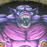 frammento di graffiti disegni. il vecchio parete decorato con dipingere macchie nel il stile di strada arte cultura. viola pauroso mostro foto