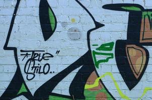 frammento di graffiti disegni. il vecchio parete decorato con dipingere macchie nel il stile di strada arte cultura. colorato sfondo struttura nel verde toni foto