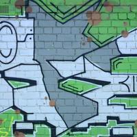 frammento di graffiti disegni. il vecchio parete decorato con dipingere macchie nel il stile di strada arte cultura. colorato sfondo struttura nel verde toni foto