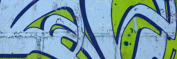 frammento di graffiti disegni. il vecchio parete decorato con dipingere macchie nel il stile di strada arte cultura. colorato sfondo struttura nel verde toni foto