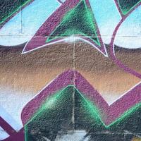 frammento di graffiti disegni. il vecchio parete decorato con dipingere macchie nel il stile di strada arte cultura. colorato sfondo struttura nel freddo toni foto