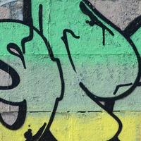 frammento di graffiti disegni. il vecchio parete decorato con dipingere macchie nel il stile di strada arte cultura. colorato sfondo struttura nel verde toni foto