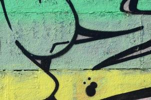 frammento di graffiti disegni. il vecchio parete decorato con dipingere macchie nel il stile di strada arte cultura. colorato sfondo struttura nel verde toni foto