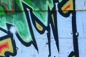 frammento di graffiti disegni. il vecchio parete decorato con dipingere macchie nel il stile di strada arte cultura. colorato sfondo struttura nel verde toni foto