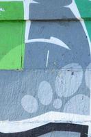 frammento di graffiti disegni. il vecchio parete decorato con dipingere macchie nel il stile di strada arte cultura. colorato sfondo struttura nel verde toni foto