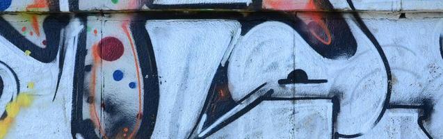 frammento di graffiti disegni. il vecchio parete decorato con dipingere macchie nel il stile di strada arte cultura. colorato sfondo struttura foto