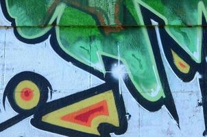 frammento di graffiti disegni. il vecchio parete decorato con dipingere macchie nel il stile di strada arte cultura. colorato sfondo struttura nel verde toni foto