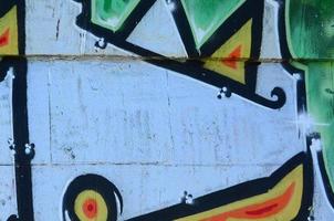 frammento di graffiti disegni. il vecchio parete decorato con dipingere macchie nel il stile di strada arte cultura. colorato sfondo struttura nel verde toni foto