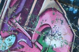 frammento di graffiti disegni. il vecchio parete decorato con dipingere macchie nel il stile di strada arte cultura. colorato sfondo struttura nel viola toni foto