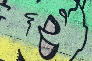 frammento di graffiti disegni. il vecchio parete decorato con dipingere macchie nel il stile di strada arte cultura. colorato sfondo struttura nel verde toni foto
