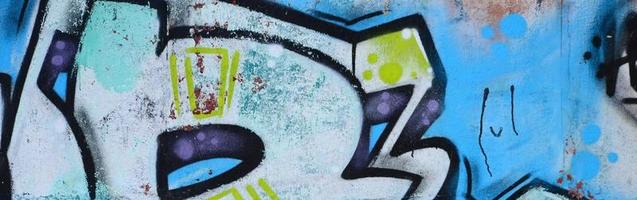 frammento di graffiti disegni. il vecchio parete decorato con dipingere macchie nel il stile di strada arte cultura. colorato sfondo struttura nel freddo toni foto