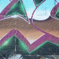 frammento di graffiti disegni. il vecchio parete decorato con dipingere macchie nel il stile di strada arte cultura. colorato sfondo struttura nel freddo toni foto