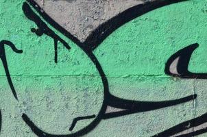 frammento di graffiti disegni. il vecchio parete decorato con dipingere macchie nel il stile di strada arte cultura. colorato sfondo struttura nel verde toni foto