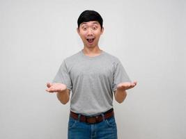 asiatico uomo grigio camicia mostrare mani su per trasportare qualcosa si sente stupito guardare esso isolato foto