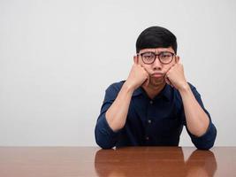 asiatico uomo d'affari indossare bicchieri sedersi a il tavolo si sente noioso foto