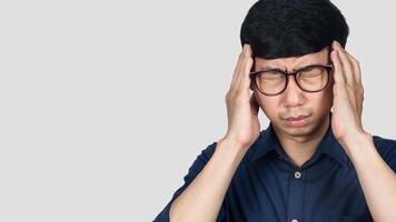 asiatico uomo indossare bicchieri si sente mal di testa con emicrania isolato foto