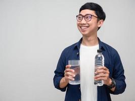 ritratto uomo hold acqua bottiglia con bicchieri di acqua dolce Sorridi guardare a copia spazio foto