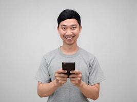 positivo asiatico uomo grigio camicia hold mobile Telefono contento Sorridi isolato foto