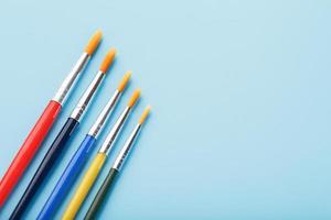 spazzole di diverso colori per disegno, creatività e arte su un' blu sfondo. foto