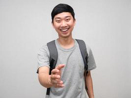 asiatico uomo con Borsa contento Sorridi gesto shake mano per voi foto