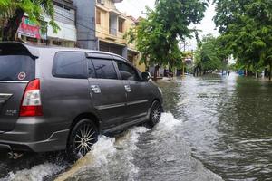 semarang, dicembre 2022. alcuni persone siamo a piedi attraverso il alluvione quello colpire il poncol treno stazione la zona e alcuni residenti siamo preparazione per evacuare. veicoli colpire il alluvione foto