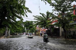 semarang, dicembre 2022. alcuni persone siamo a piedi attraverso il alluvione quello colpire il poncol treno stazione la zona e alcuni residenti siamo preparazione per evacuare. veicoli colpire il alluvione foto