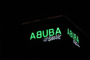 bekasi, Indonesia nel luglio 2022. Abuba bistecca logo splendente brillantemente a notte contro il buio notte cielo. foto