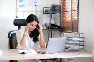 stanco femmina dipendente Tenere testa su mano, guardare a computer schermo, fare difficile compito, avendo problema con computer Software. stressato esausto donna d'affari sofferenza a partire dal male alla testa, sensazione annoiato. foto