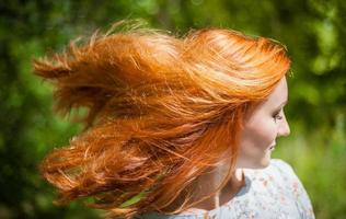 ritratto di un' ragazza con rosso capelli svolazzanti nel il vento. foto