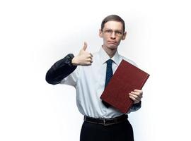 un uomo d'affari in cravatta e occhiali con una rivista in mano su uno sfondo bianco e isolato foto