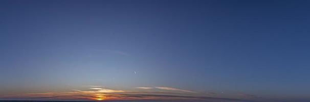 immagine di drammatico e colorato cielo con sole durante tramonto foto