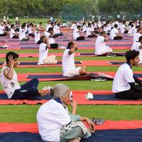 nuovo delhi, India, giugno 21 2022 - gruppo yoga esercizio sessione per persone a yamuna gli sport complesso nel delhi su internazionale yoga giorno, grande gruppo di adulti frequentando yoga classe nel cricket stadio foto