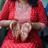 bellissimo donna vestito su come indiano tradizione con alcanna mehndi design su sua tutti e due mani per celebrare grande Festival di karwa chaut, karwa chauth celebrazioni di indiano donna per sua marito foto