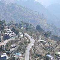 vista aerea dall'alto dei veicoli stradali che guidano su strade di montagna a nainital, india, uttarakhand, vista dal lato superiore della montagna per il movimento di veicoli stradali foto