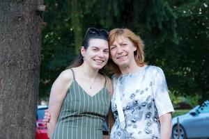 bellissimo anziano madre e sua adulto figlia Guarda a il telecamera e Sorridi foto