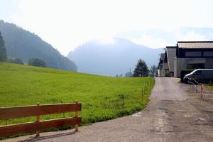 viaggio per sankt-wolfgang, Austria. il Visualizza su il strada vicino per verde prato con il case e il montagne su il sfondo. foto