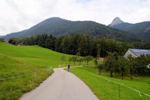 viaggio per sankt-wolfgang, Austria. il strada fra i campi con il case e il montagne su il sfondo. foto