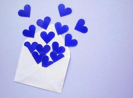 blu cuori e bianca Busta su blu sfondo. romantico Messaggio, lettera, regalo, saluto carta per San Valentino giorno concetto. vacanza festivo creativo design amore composizione. piatto, superiore Visualizza foto