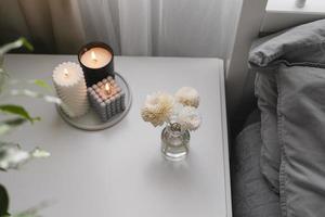 aromatico canna aria deodorante e ardente candela su capezzale tavolo nel il Camera da letto. casa aroma. benessere foto