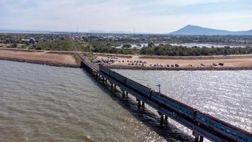 aereo Visualizza di un sorprendente viaggio treno parcheggiata su un' galleggiante ferrovia ponte al di sopra di il acqua di il lago nel papà sak jolasid diga con blu cielo a lopburi, Tailandia. foto