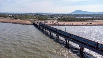 aereo Visualizza di un sorprendente viaggio treno parcheggiata su un' galleggiante ferrovia ponte al di sopra di il acqua di il lago nel papà sak jolasid diga con blu cielo a lopburi, Tailandia. foto