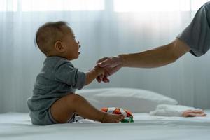 un asiatico bambino si fida il suo Il padre di mano per In piedi su. padre e figlio la spesa tempo insieme foto