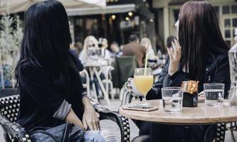 Due contento amiche guardare su il vetrina mentre in piedi con shopping borse vicino il centro commerciale foto