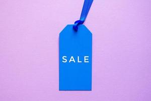 blu prezzo etichetta con vendita parola su il rosa sfondo, blu modello foto