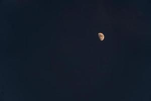 metà Luna nel il buio di notte chiaro cielo giallo Luna copia spazio foto