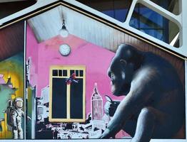 dettagliato Immagine di colore graffiti disegno. sfondo strada arte sfondo con un' dipinto scimmia, guardare a il città attraverso un' ingrandimento bicchiere foto
