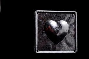 argento cuore forma su nero sfondo foto